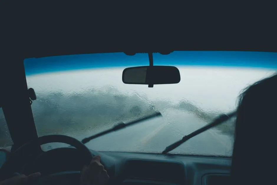 Voiture roulant sous une forte pluie, essuie-glaces actifs, route détrempée